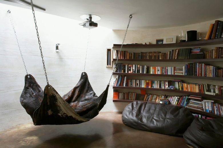 Garaža, predelana v bivalni prostor s knjižnimi policami, visečo mrežo in sedišči.