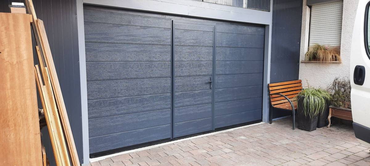 Črna elegantna sekcijska garažna vrata s sijajnim zaključkom na urbani rezidenci